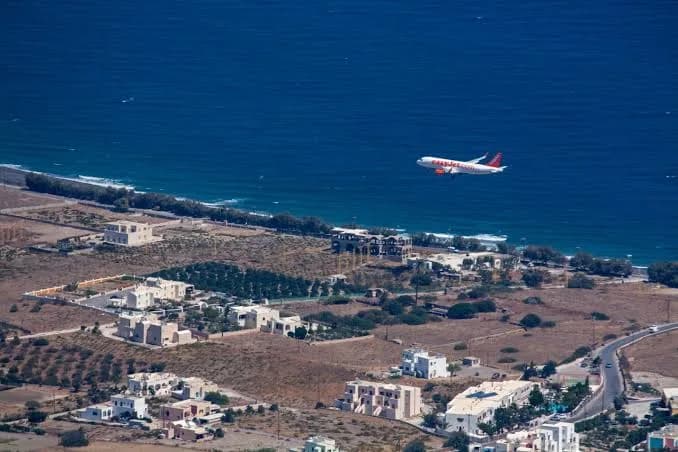 Aircraft departing Santorini Airport along the island coastline, Greece